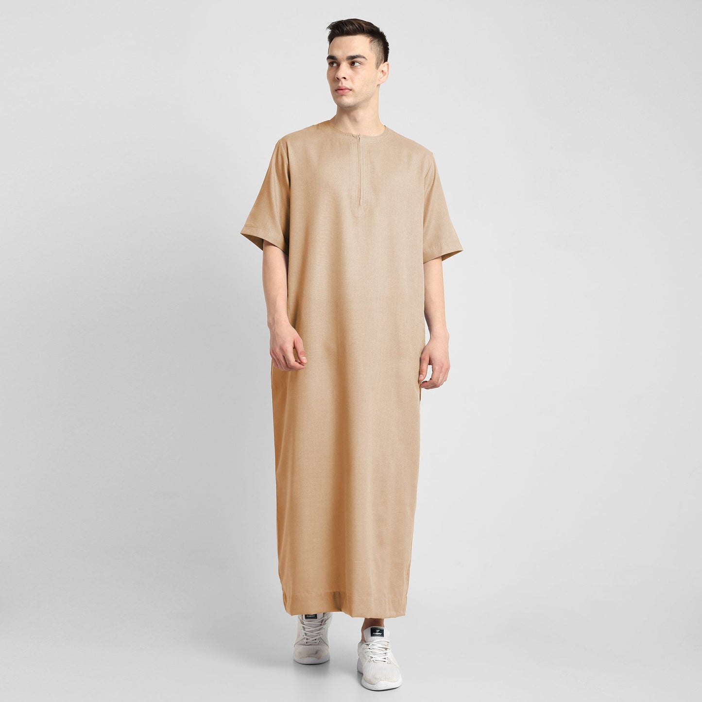 Man wearing a Beige, ankle-length thobe with a relaxed fit, embodying a fusion of traditional charm and modern simplicity
