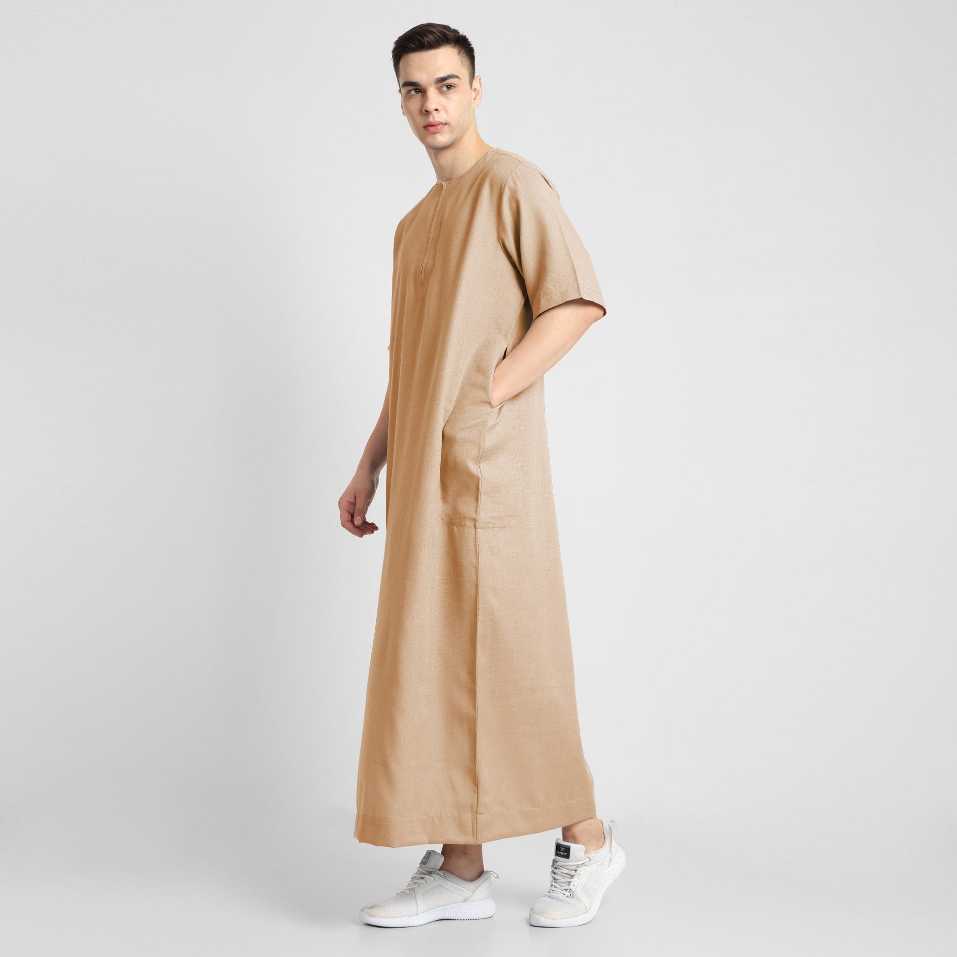 Man wearing a Beige, ankle-length thobe with a relaxed fit, embodying a fusion of traditional charm and modern simplicity