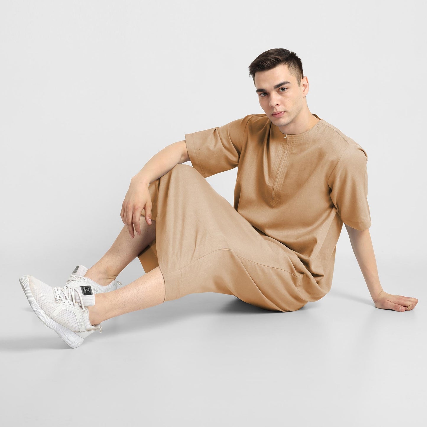 Man wearing a Beige, ankle-length thobe with a relaxed fit, embodying a fusion of traditional charm and modern simplicity