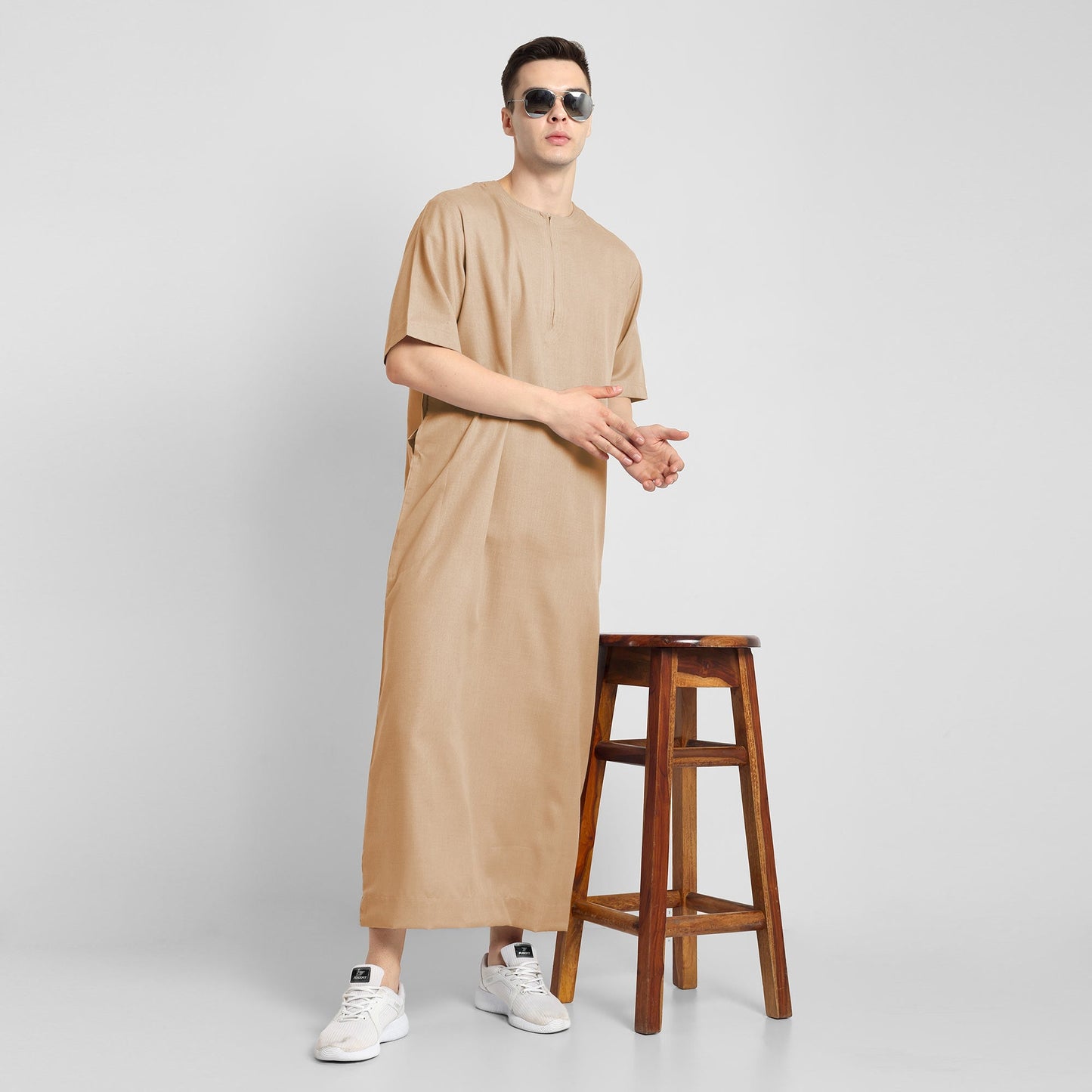 Man wearing a Beige, ankle-length thobe with a relaxed fit, embodying a fusion of traditional charm and modern simplicity