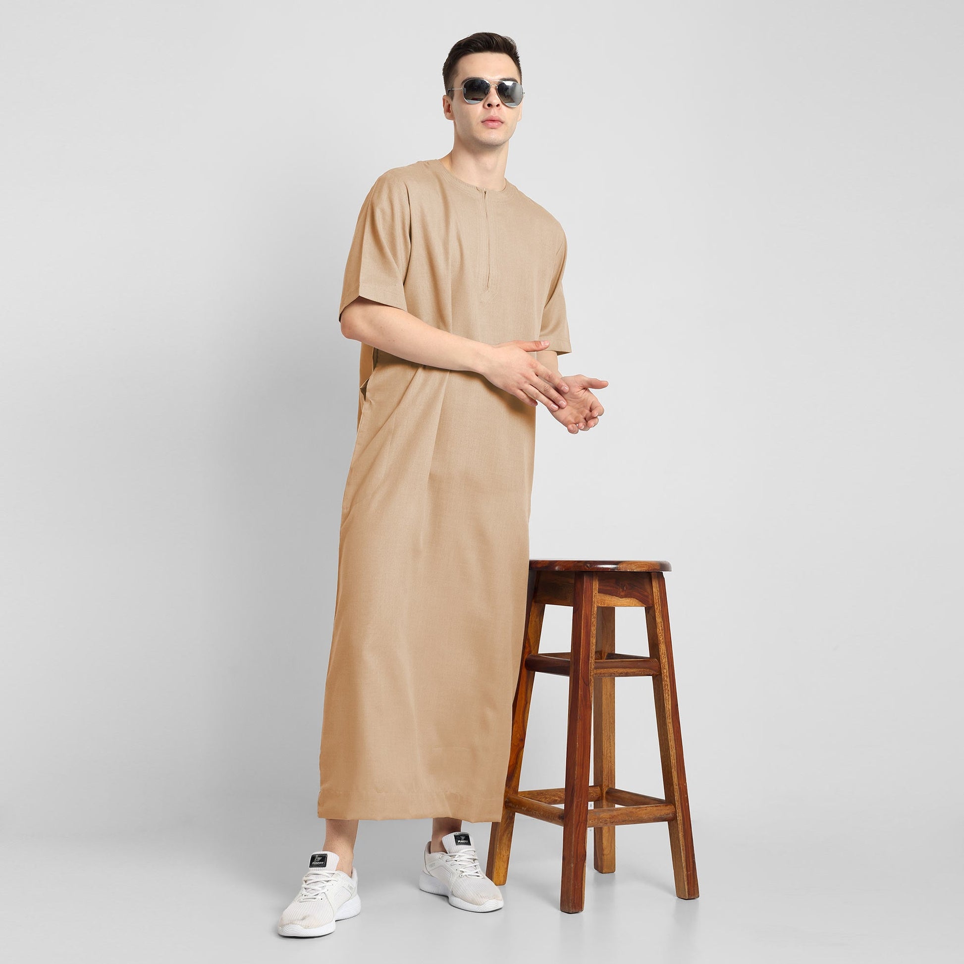 Man wearing a Beige, ankle-length thobe with a relaxed fit, embodying a fusion of traditional charm and modern simplicity