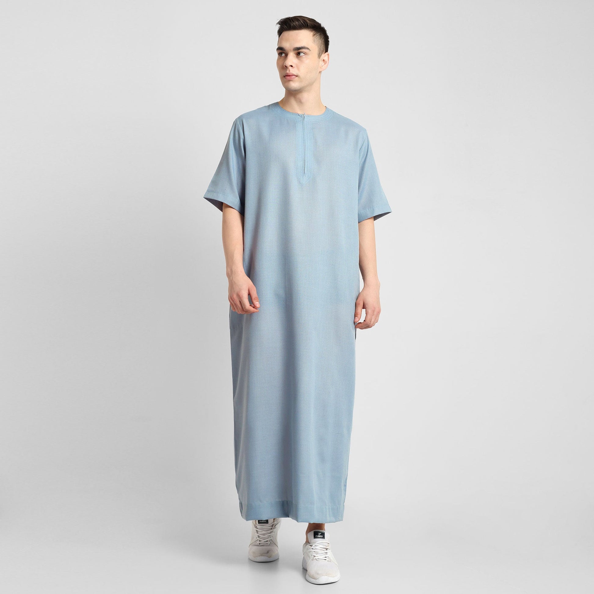 Man wearing a Blue, ankle-length thobe with a relaxed fit, embodying a fusion of traditional charm and modern simplicity