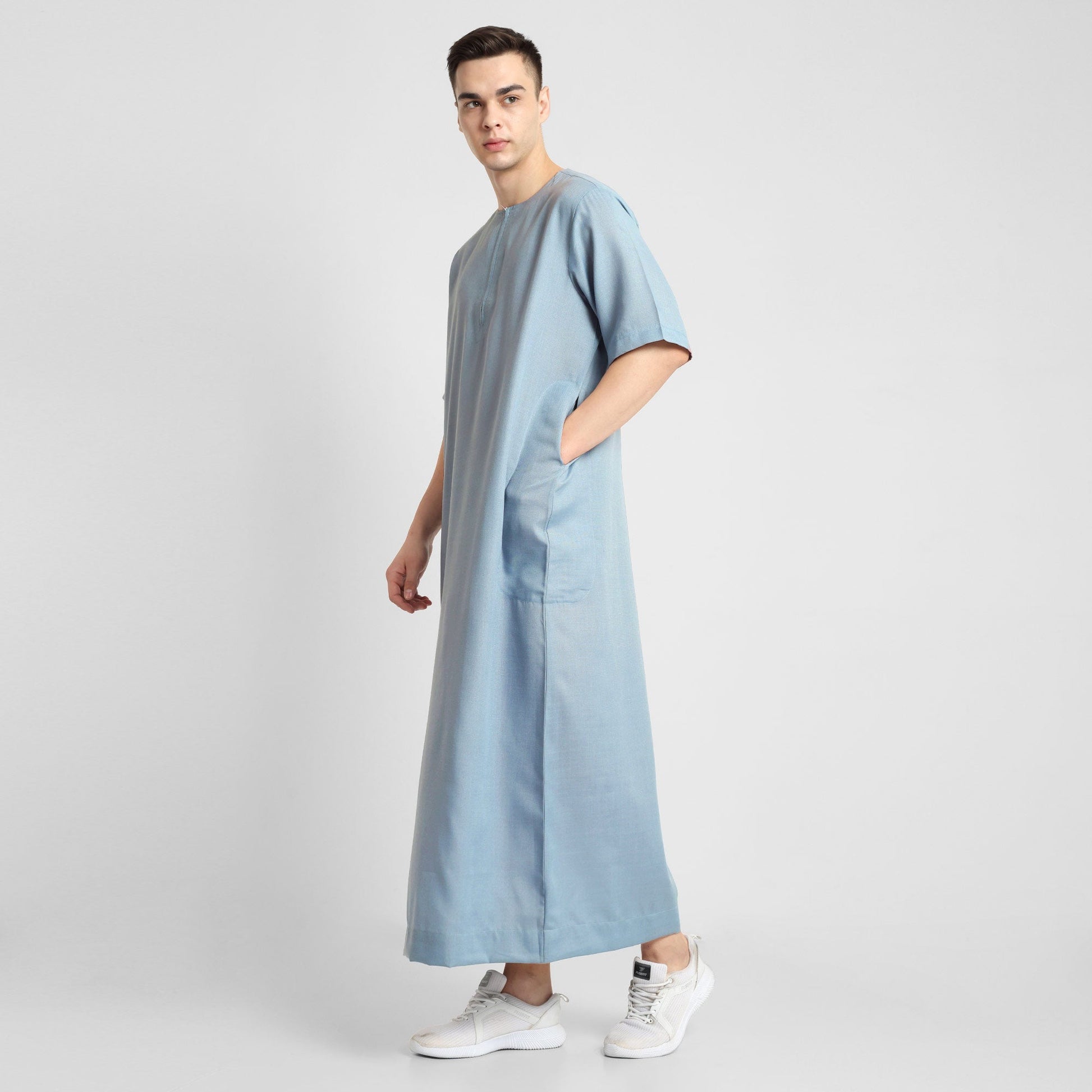 Man wearing a Blue, ankle-length thobe with a relaxed fit, embodying a fusion of traditional charm and modern simplicity