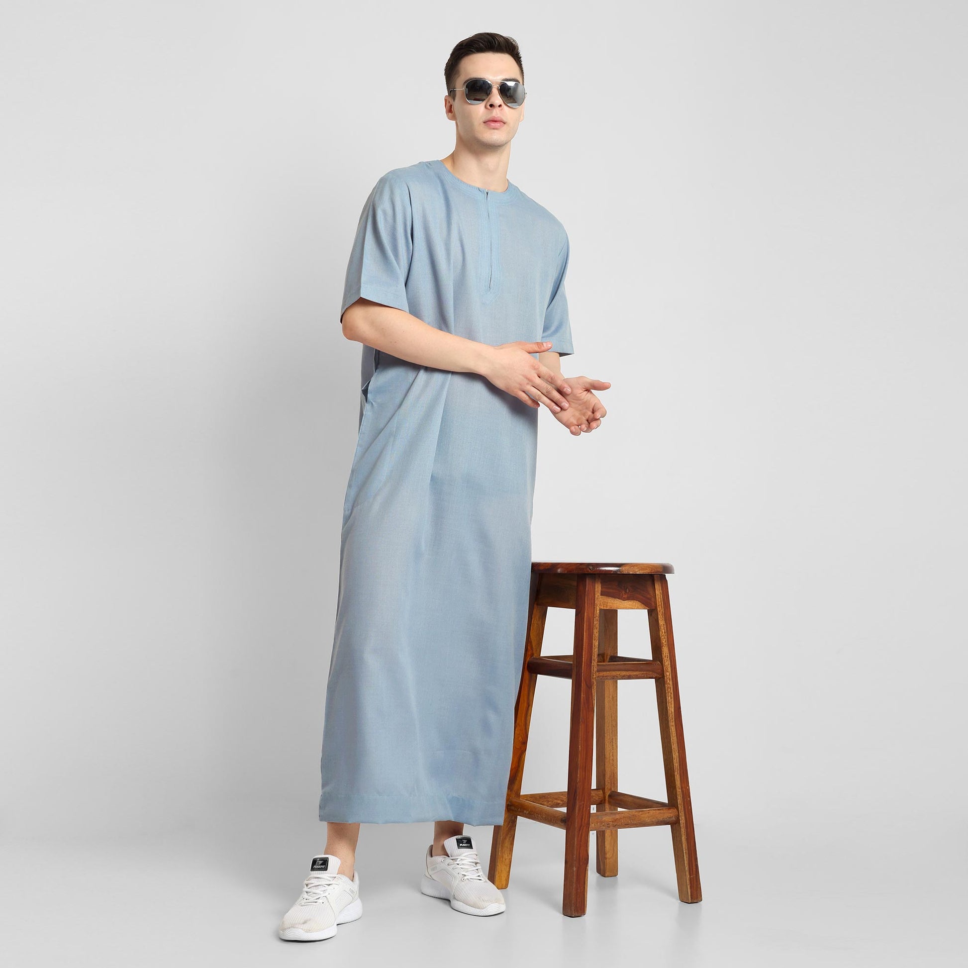 Man wearing a Blue, ankle-length thobe with a relaxed fit, embodying a fusion of traditional charm and modern simplicity