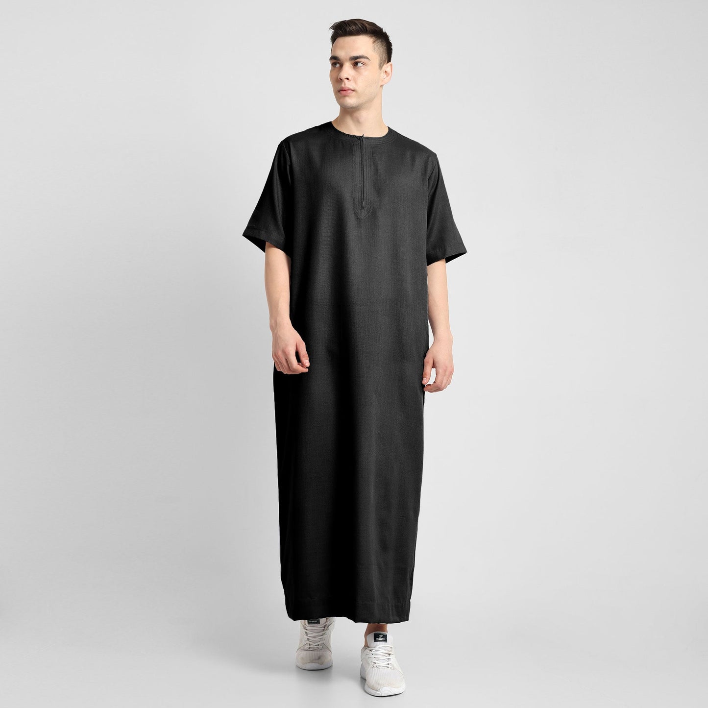 Man wearing a black, ankle-length thobe with a relaxed fit, embodying a fusion of traditional charm and modern simplicity