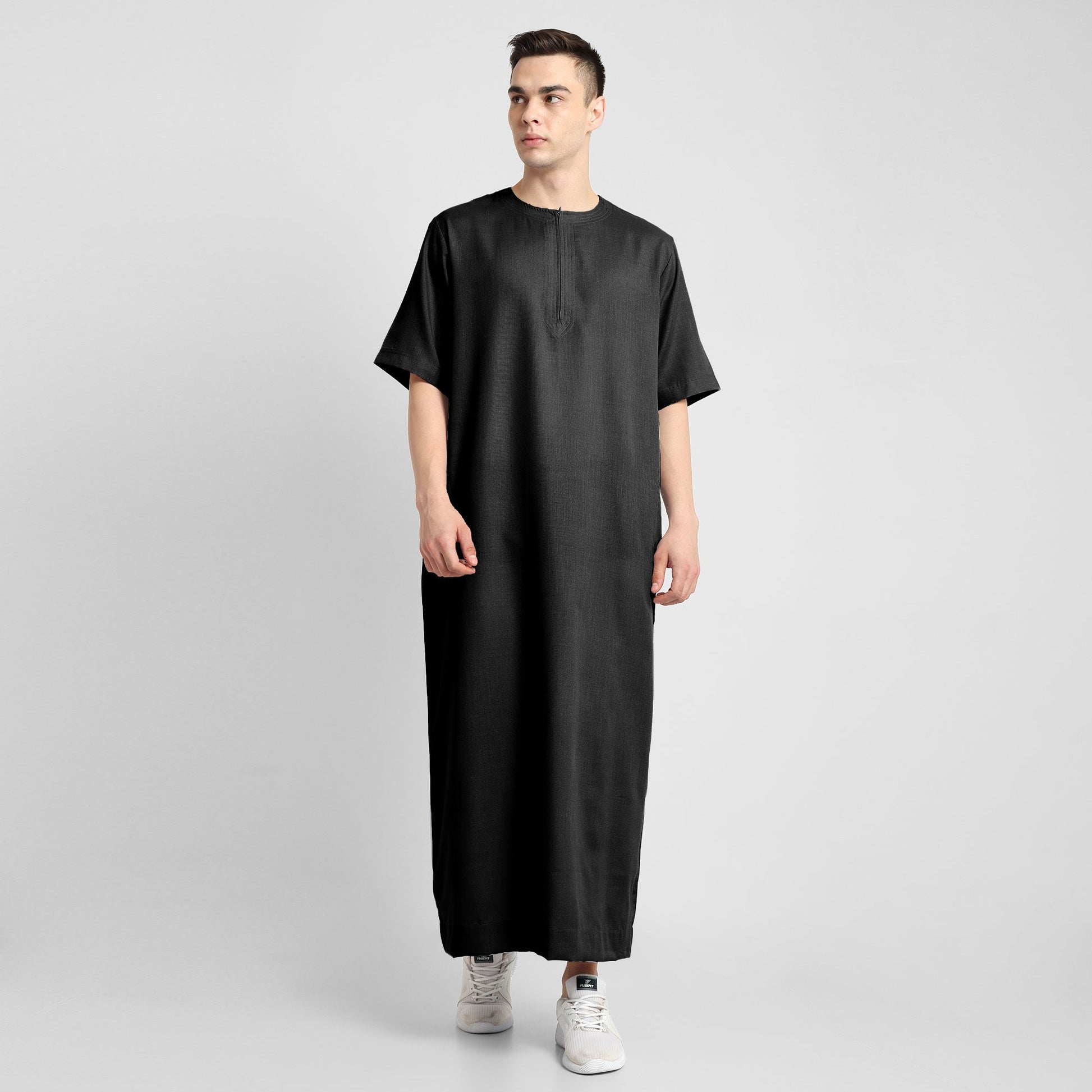 Man wearing a black, ankle-length thobe with a relaxed fit, embodying a fusion of traditional charm and modern simplicity