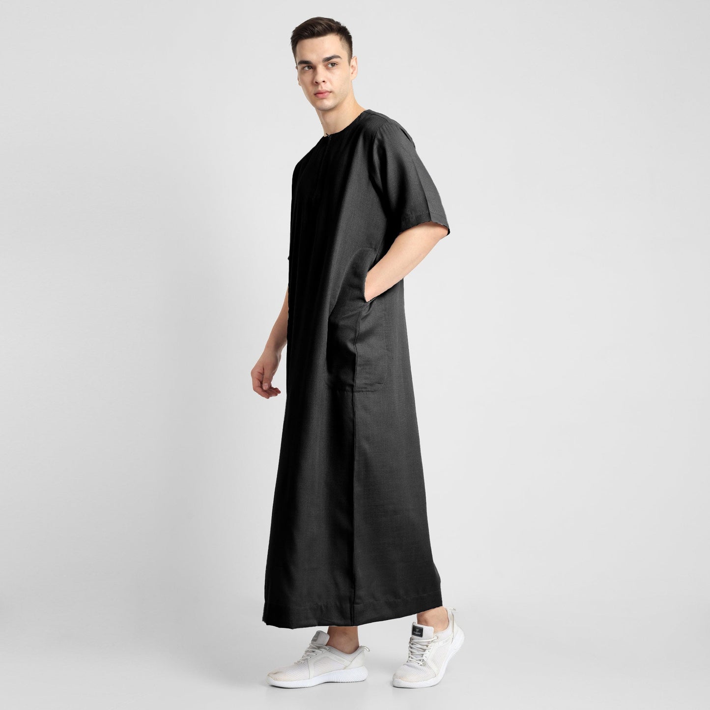 Man wearing a black, ankle-length thobe with a relaxed fit, embodying a fusion of traditional charm and modern simplicity
