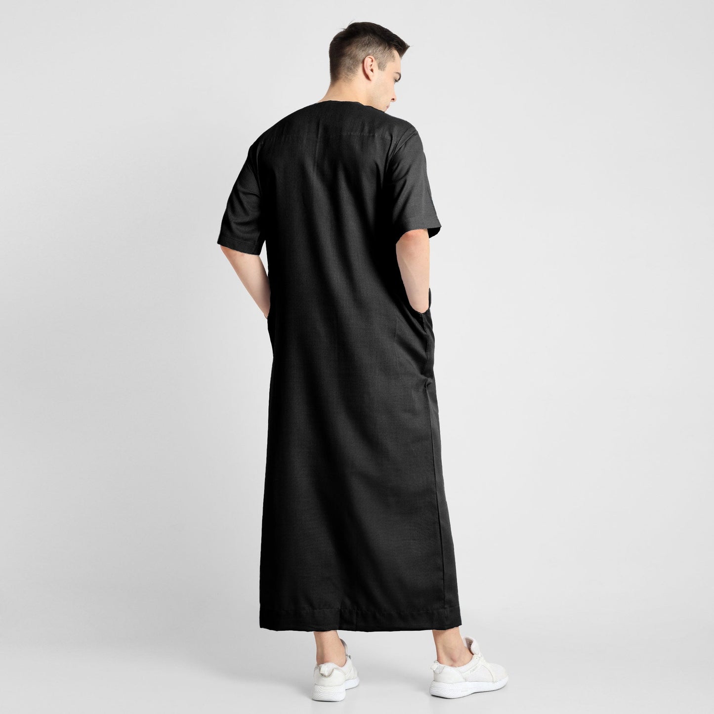 Man wearing a black, ankle-length thobe with a relaxed fit, embodying a fusion of traditional charm and modern simplicity