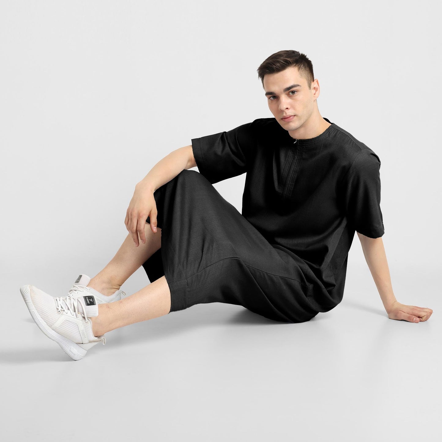 Man wearing a black, ankle-length thobe with a relaxed fit, embodying a fusion of traditional charm and modern simplicity