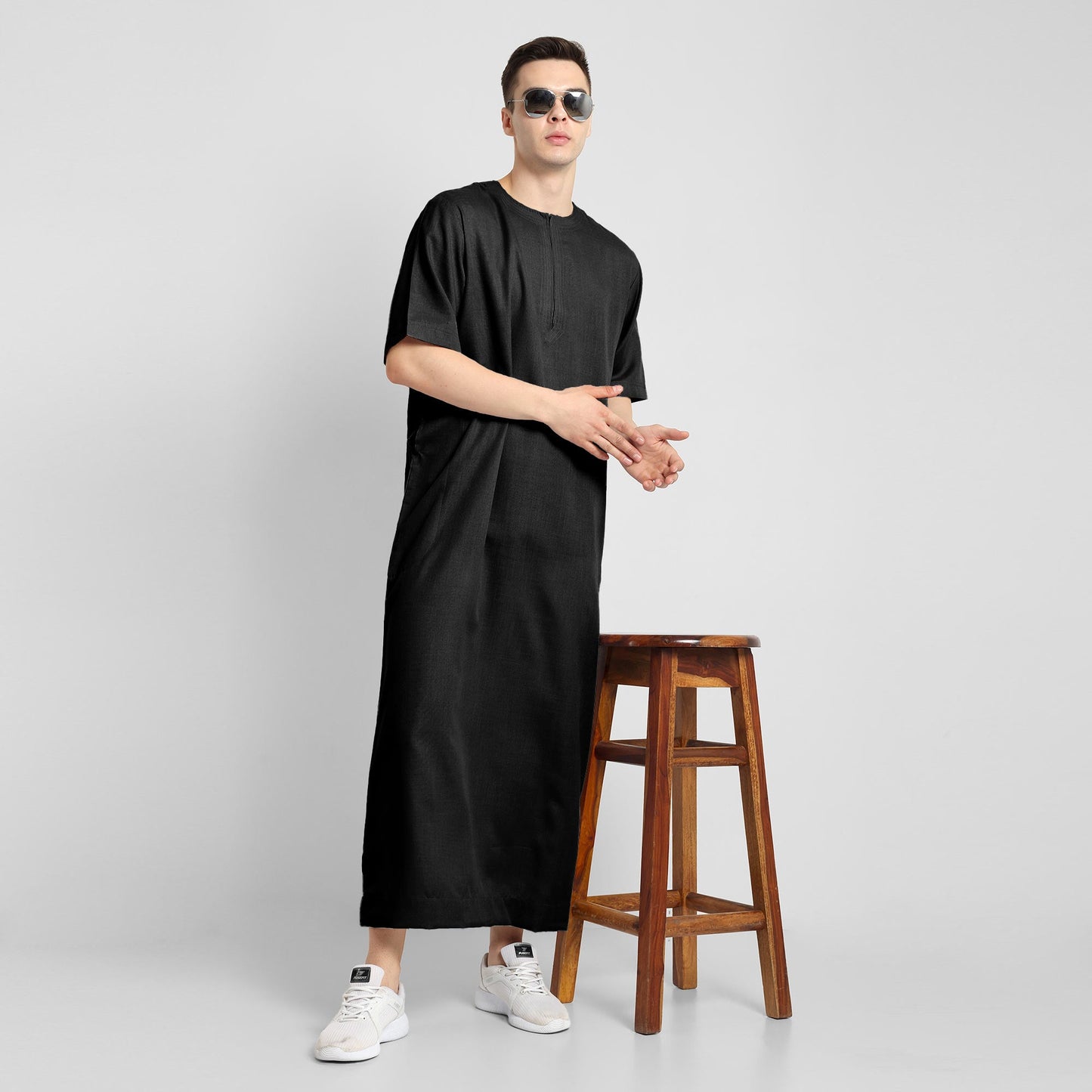 Man wearing a black, ankle-length thobe with a relaxed fit, embodying a fusion of traditional charm and modern simplicity