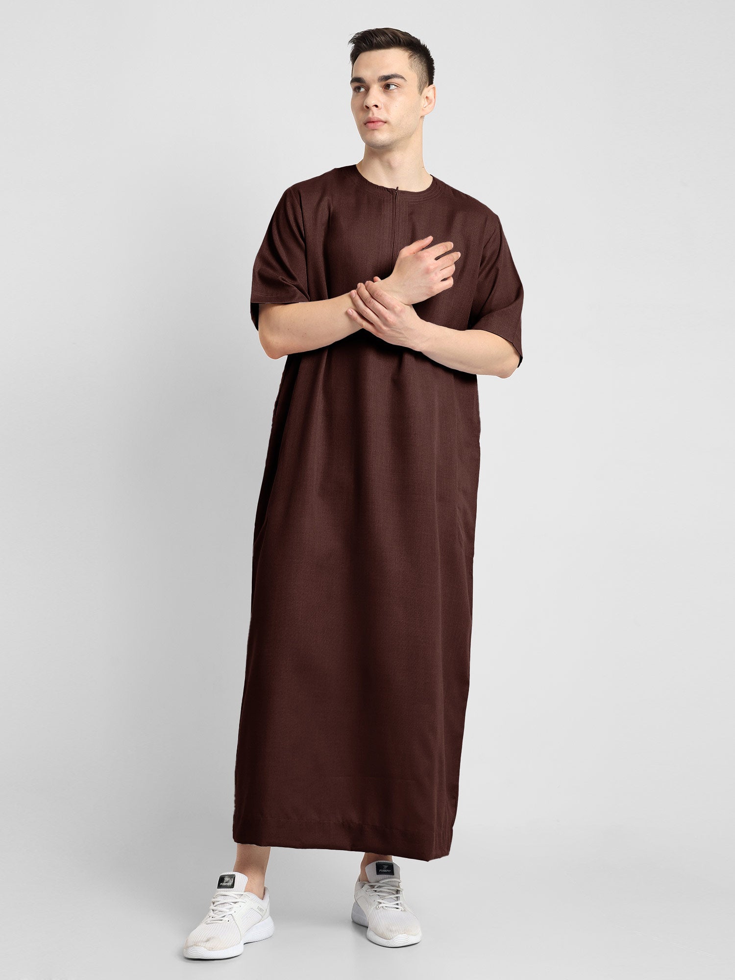 Man wearing a brown, ankle-length thobe with a relaxed fit, embodying a fusion of traditional charm and modern simplicity