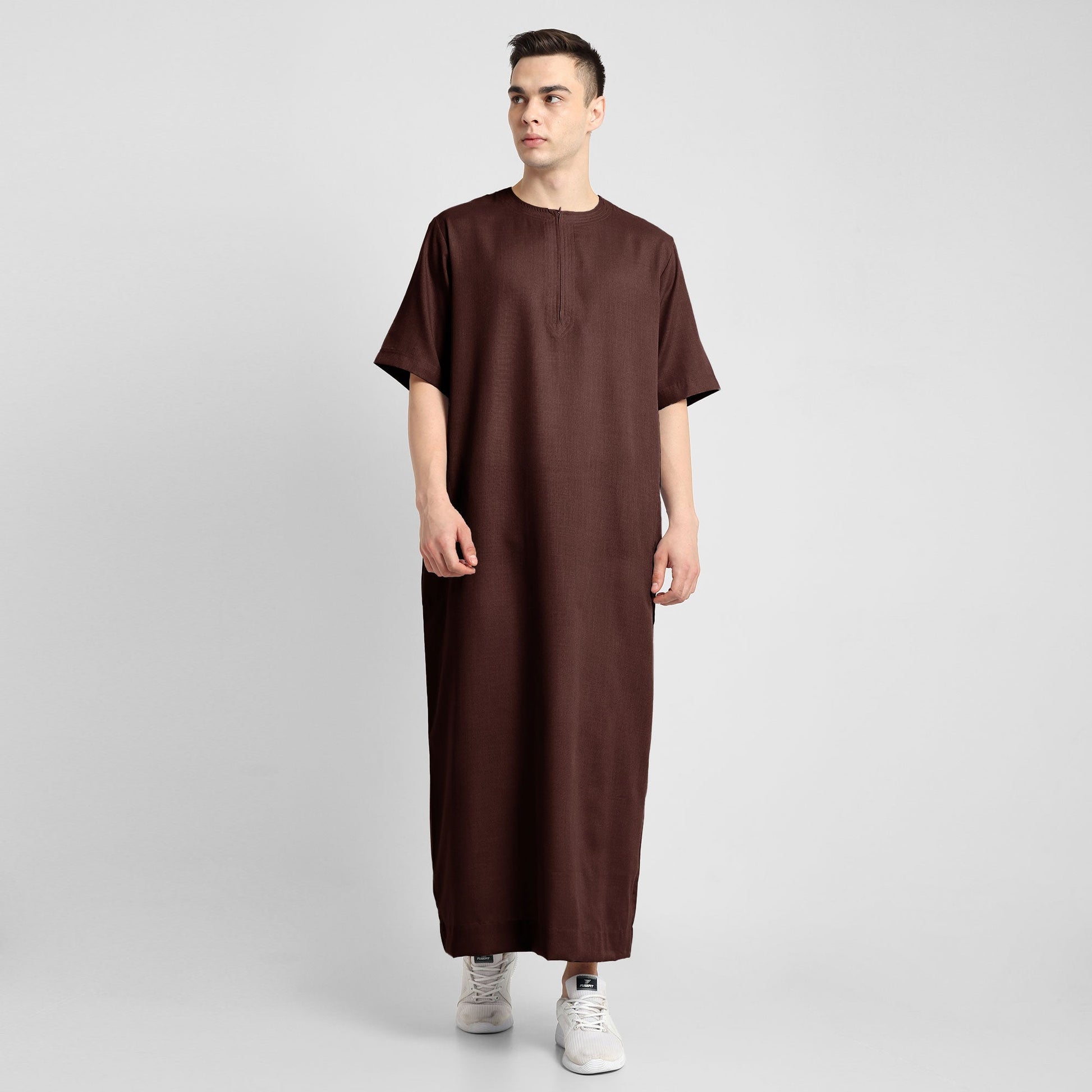 Man wearing a brown, ankle-length thobe with a relaxed fit, embodying a fusion of traditional charm and modern simplicity