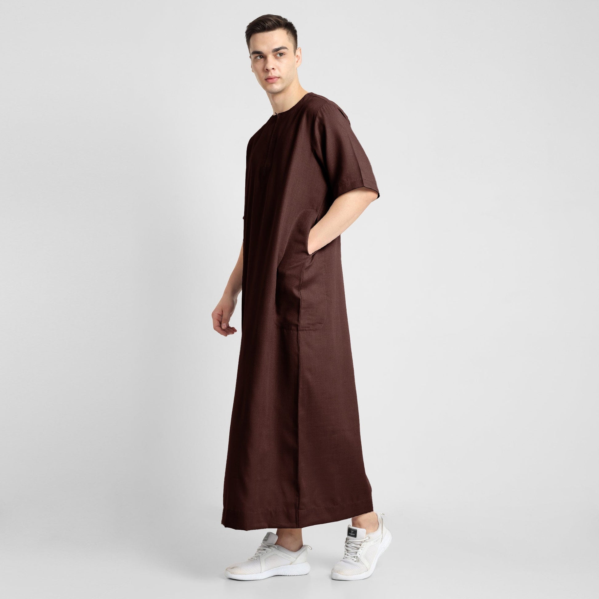 Man wearing a brown, ankle-length thobe with a relaxed fit, embodying a fusion of traditional charm and modern simplicity