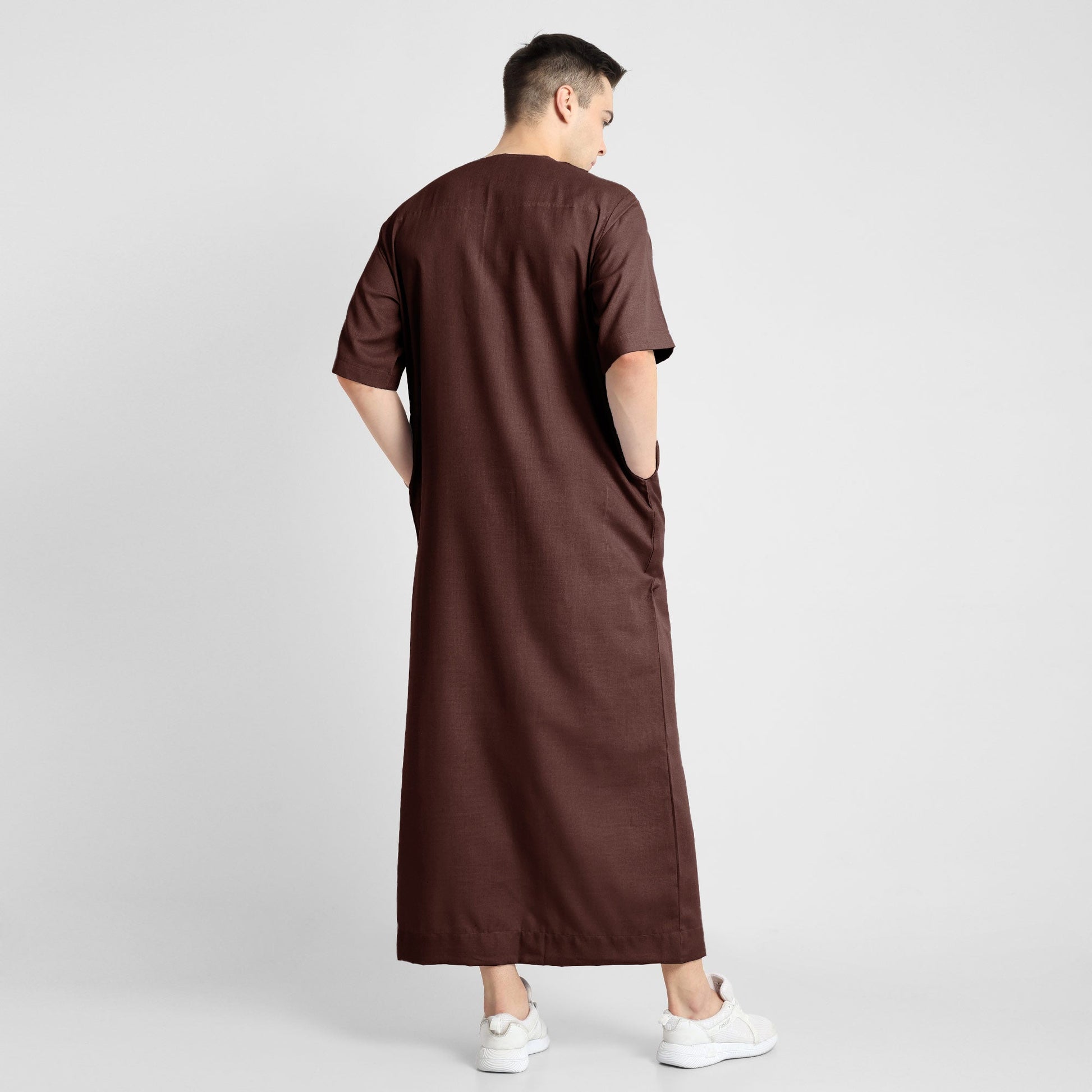 Man wearing a brown, ankle-length thobe with a relaxed fit, embodying a fusion of traditional charm and modern simplicity