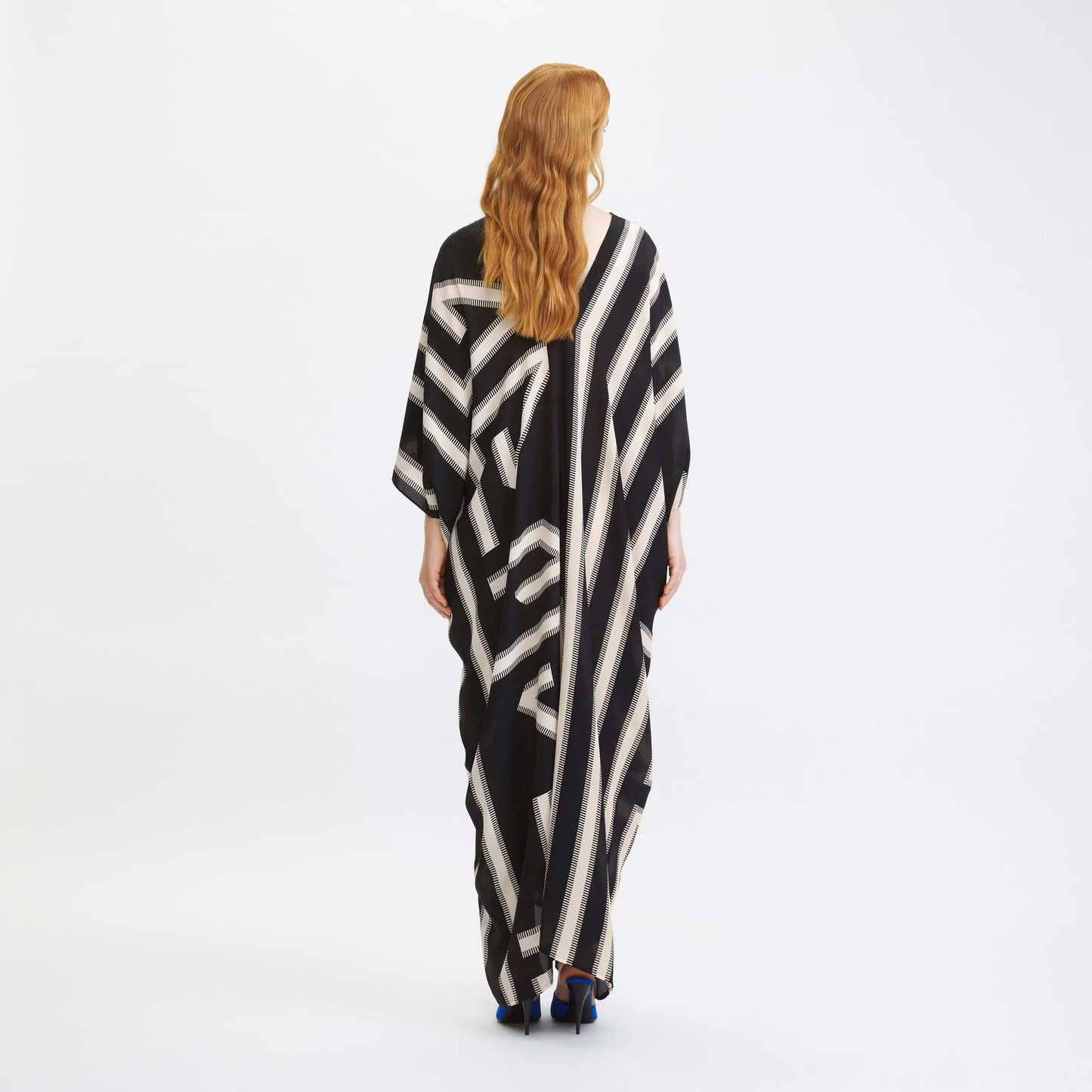 Women wearing a black and cream geometric patterned kaftan with a cinched waist