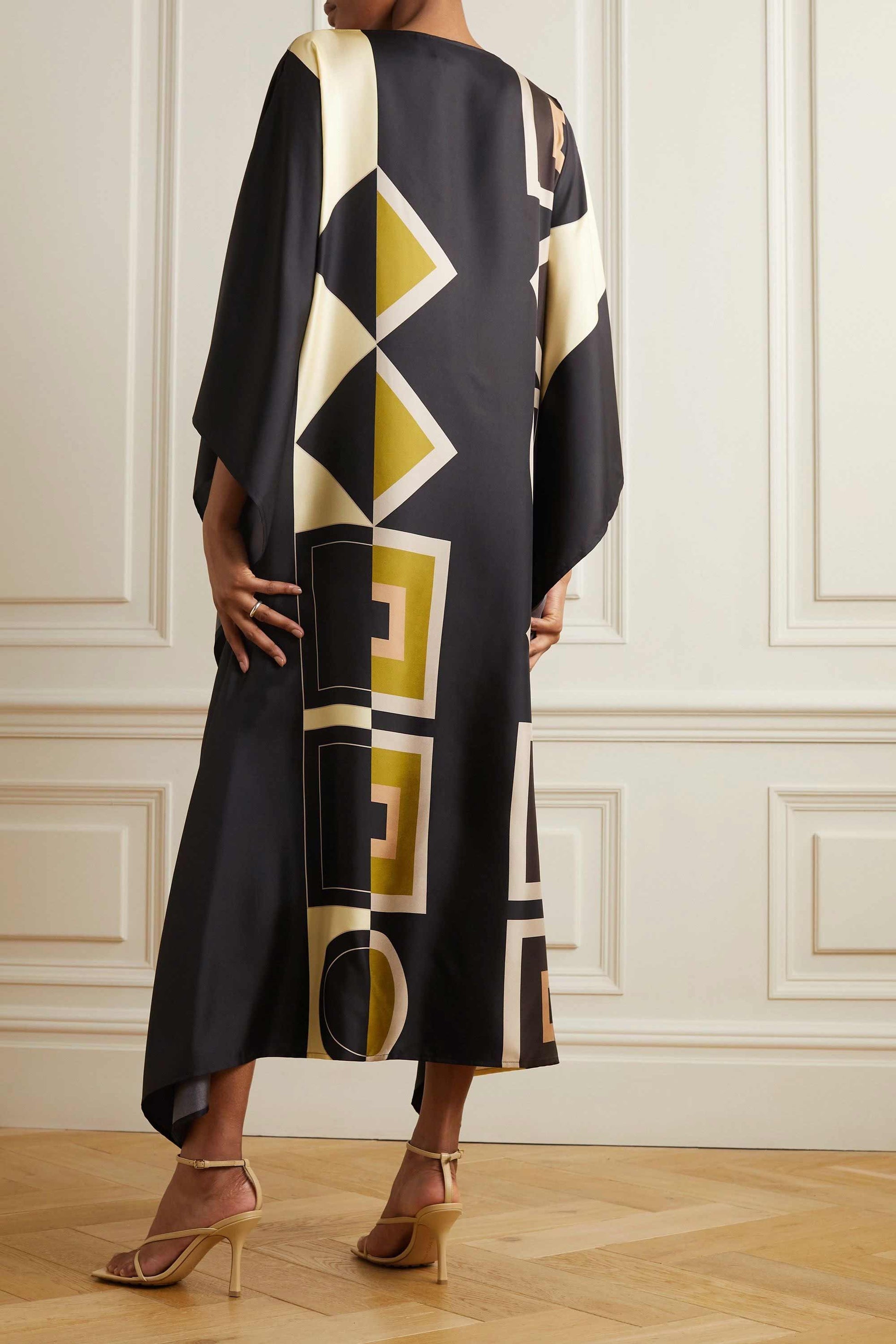 Model wearing black and cream geometric patterned kaftan with waist tie