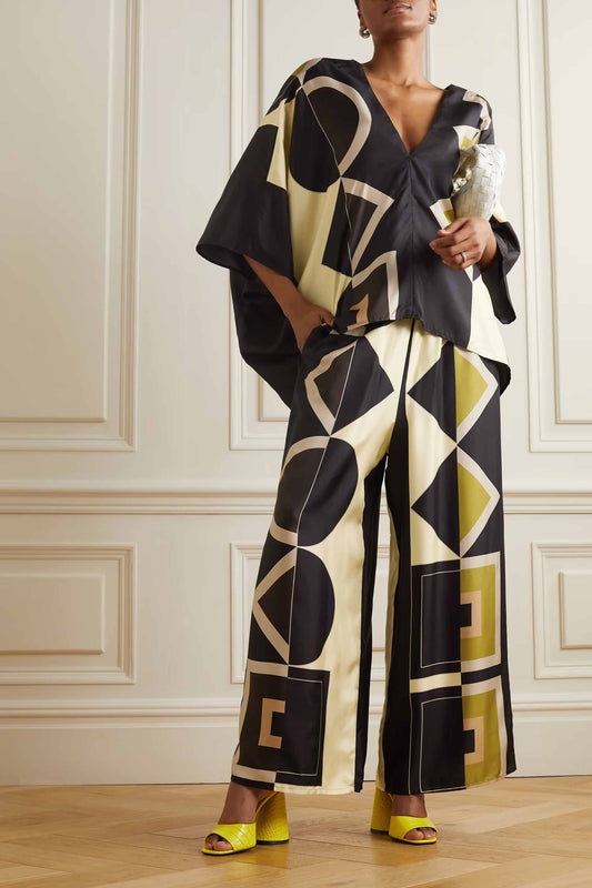 Womens in a black and cream geometric print co-ord set with wide leg pants and a V neck top.