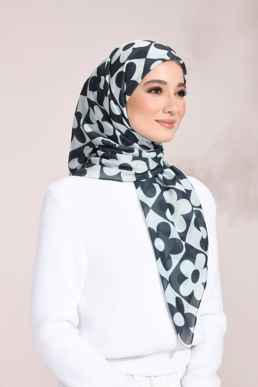 Elegant woman wearing a Monochrome Blossom Hijab with a black and white floral pattern, ideal for a sophisticated and stylish look