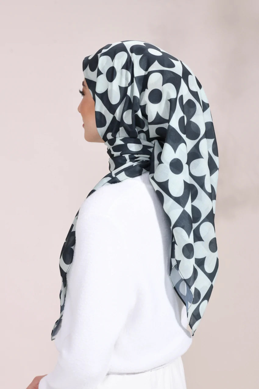 Elegant woman wearing a Monochrome Blossom Hijab with a black and white floral pattern, ideal for a sophisticated and stylish look